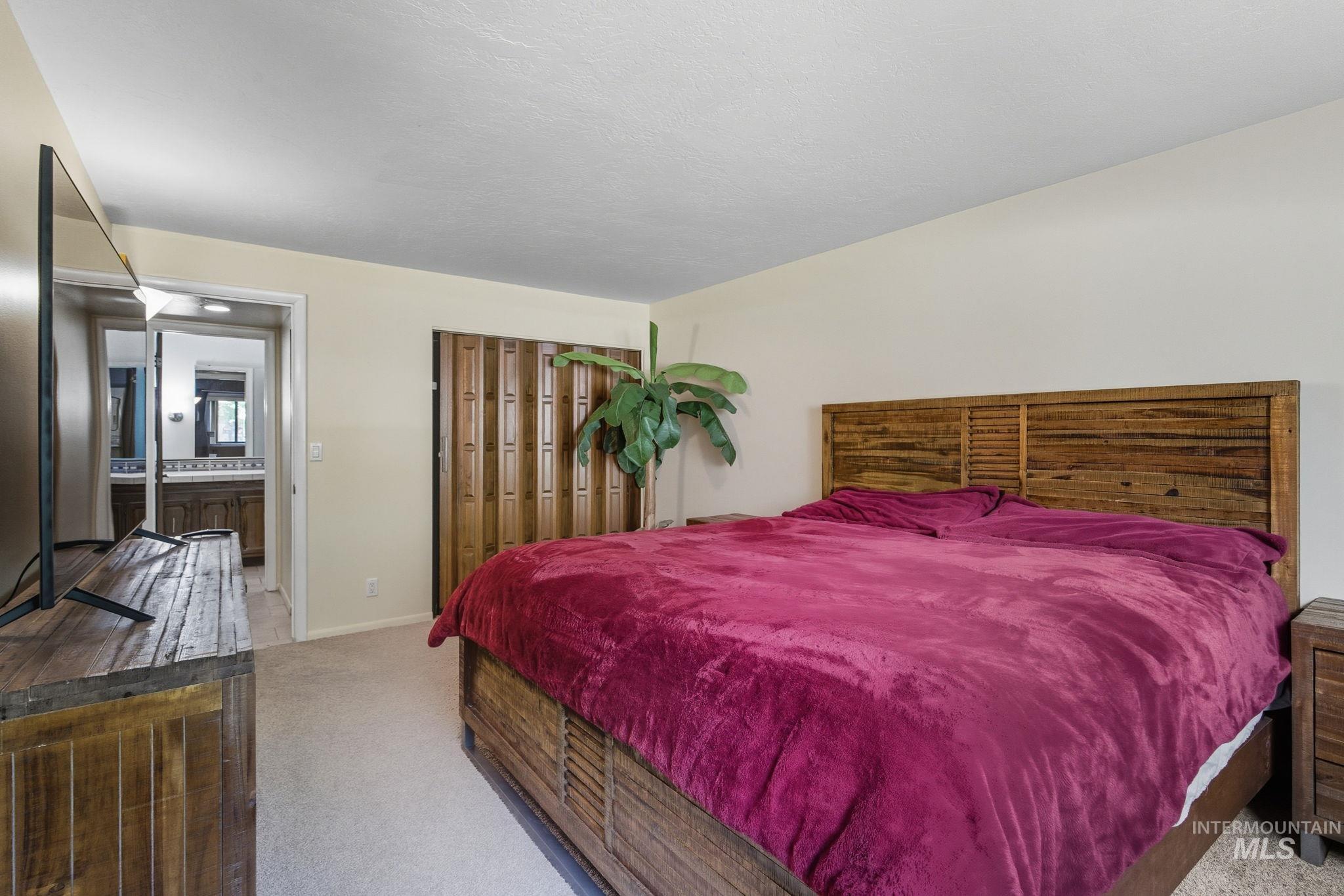 Bedroom featuring light colored carpet, a closet, and ensuite bathroom