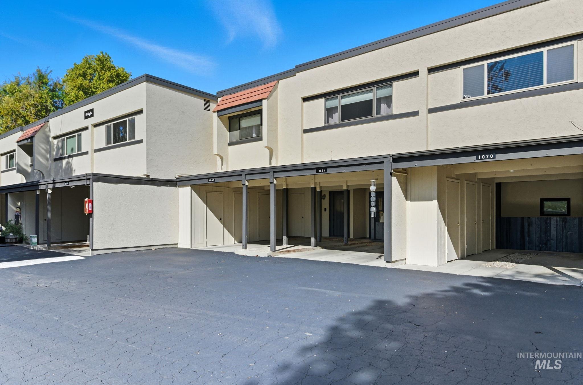 View of front facade with covered parking and stucco siding