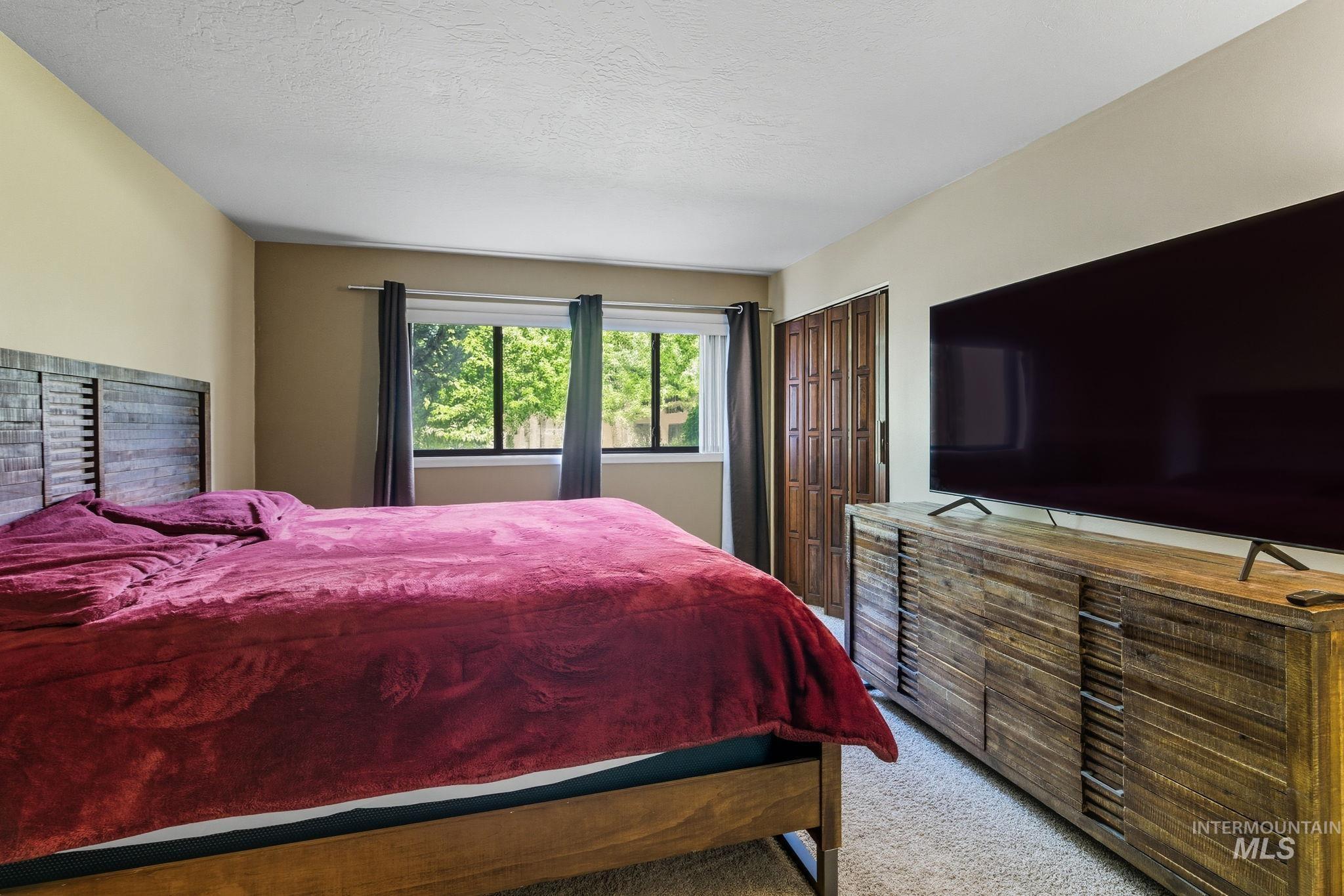Carpeted bedroom featuring a closet and a textured ceiling