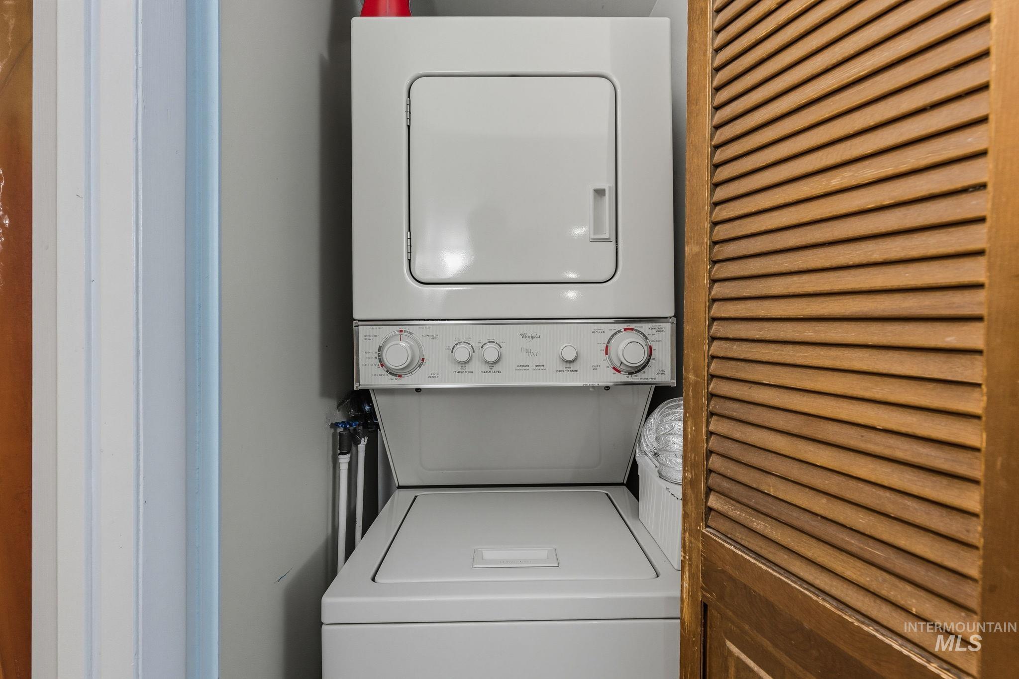 Laundry area featuring stacked washer and clothes dryer