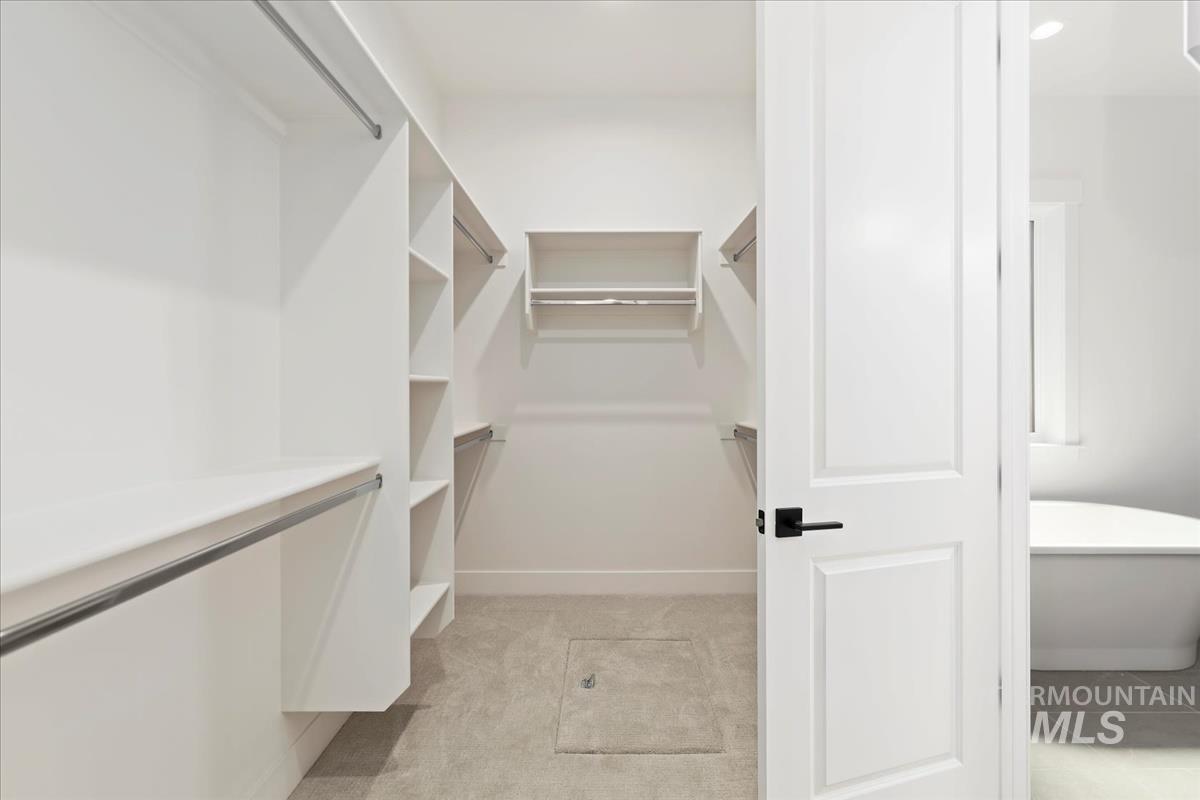 Walk in closet with light carpet