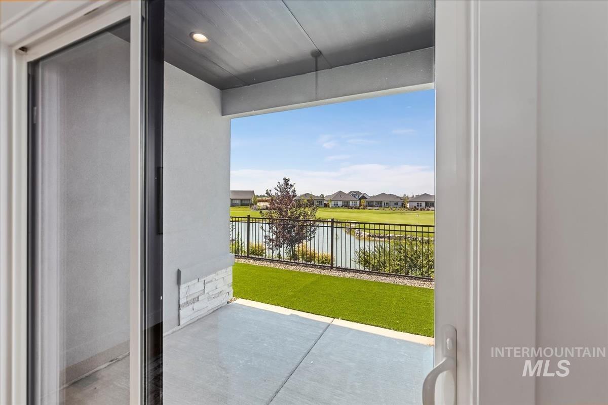 Doorway to outside with a water view, concrete floors, elevator, a residential view, and recessed lighting