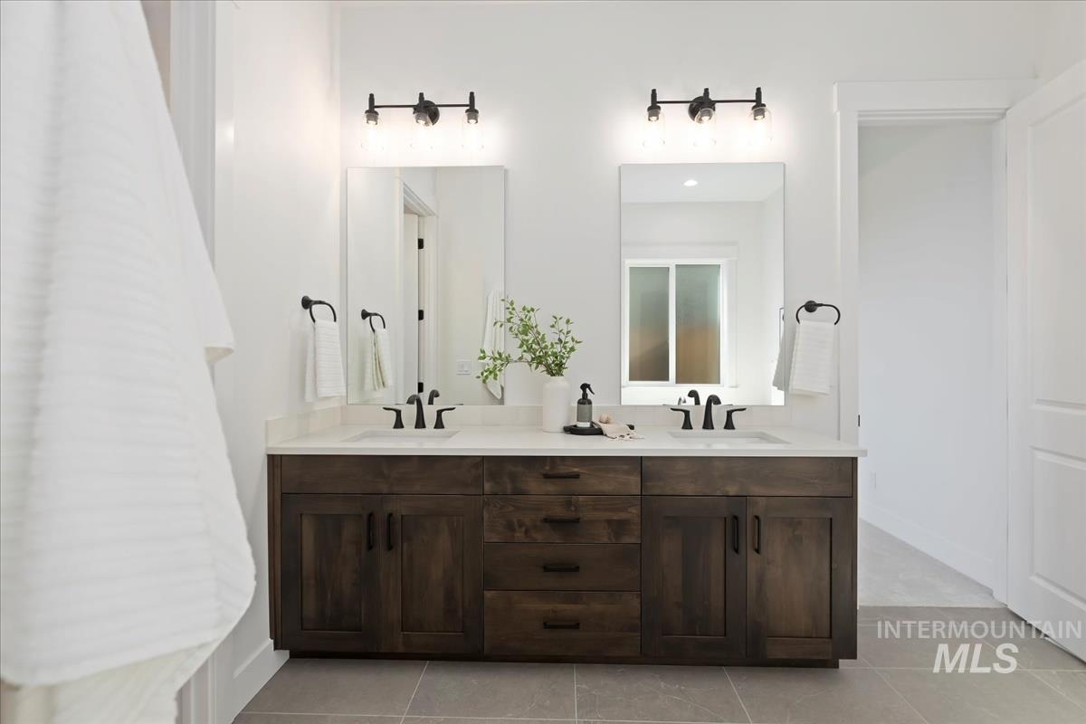 Bathroom with double vanity and light tile patterned flooring