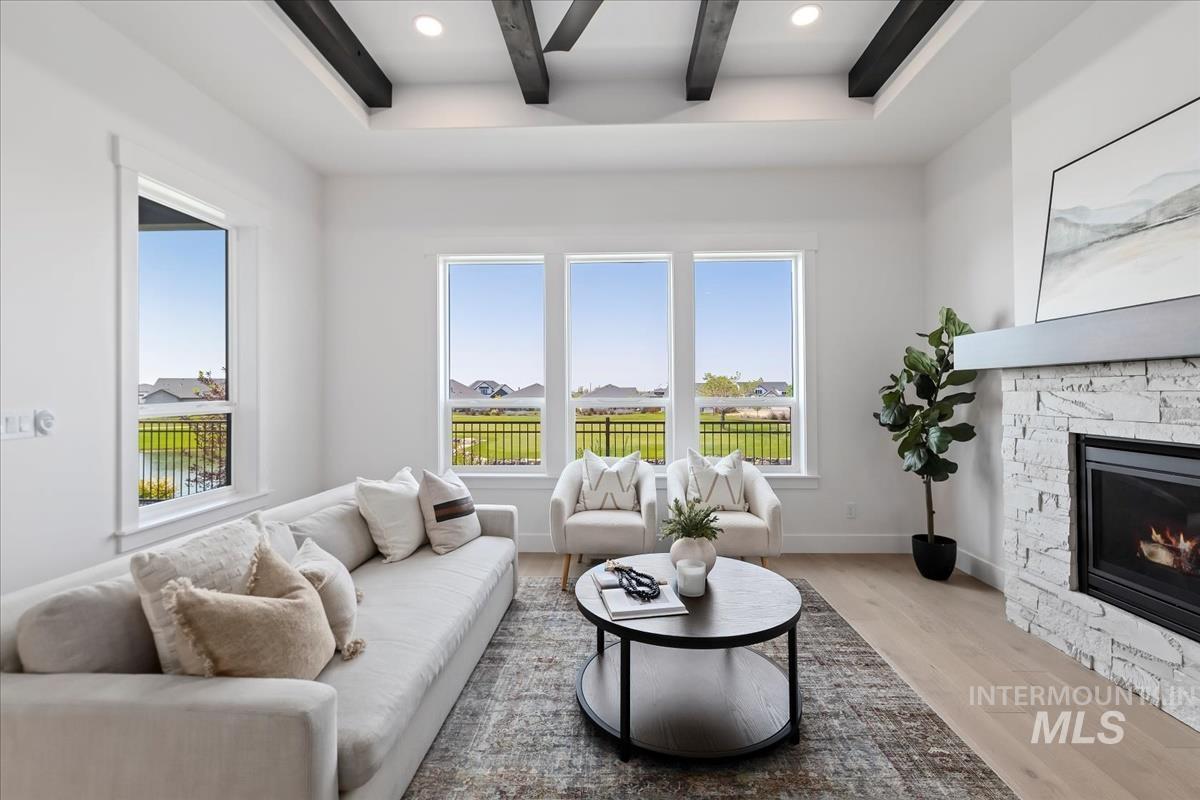 Living room with wood finished floors, a fireplace, beam ceiling, and recessed lighting
