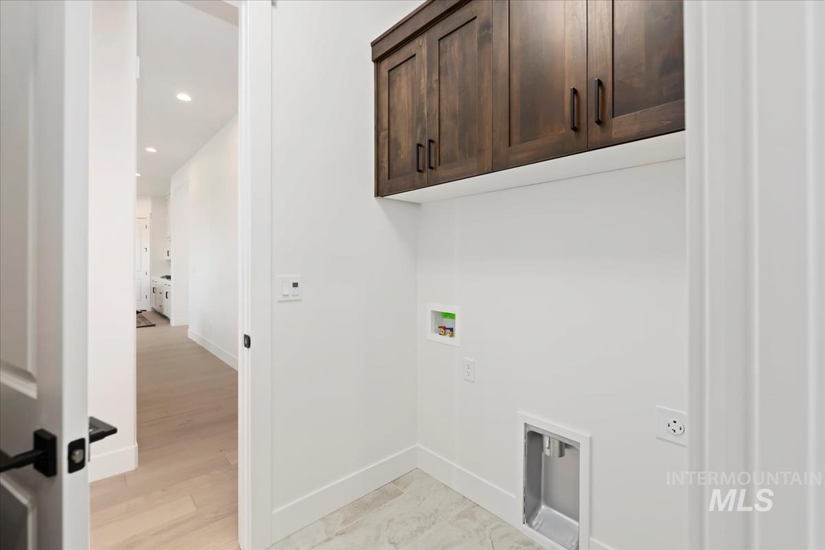 Washroom with washer hookup, cabinet space, and recessed lighting