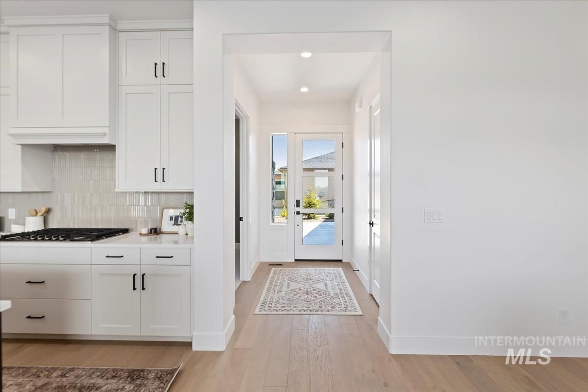 Doorway featuring wood finished floors and recessed lighting
