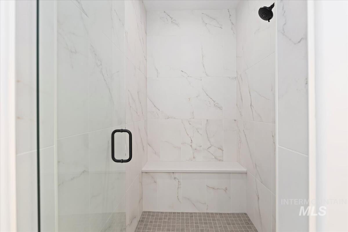 Bathroom featuring a marble finish shower