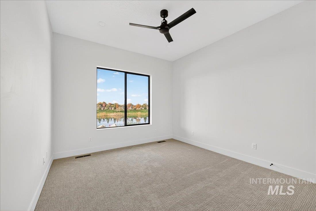 Unfurnished room featuring light colored carpet and ceiling fan