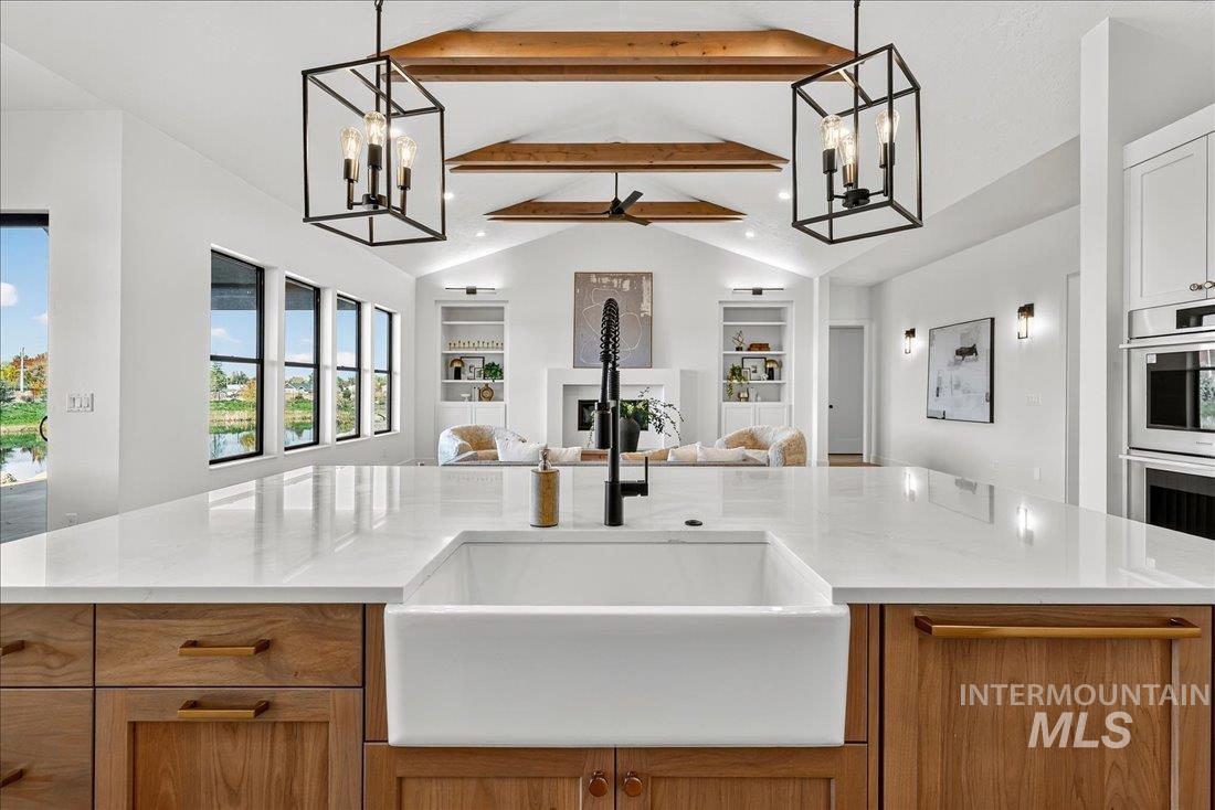 Kitchen with a chandelier, decorative light fixtures, brown cabinets, a fireplace, and recessed lighting