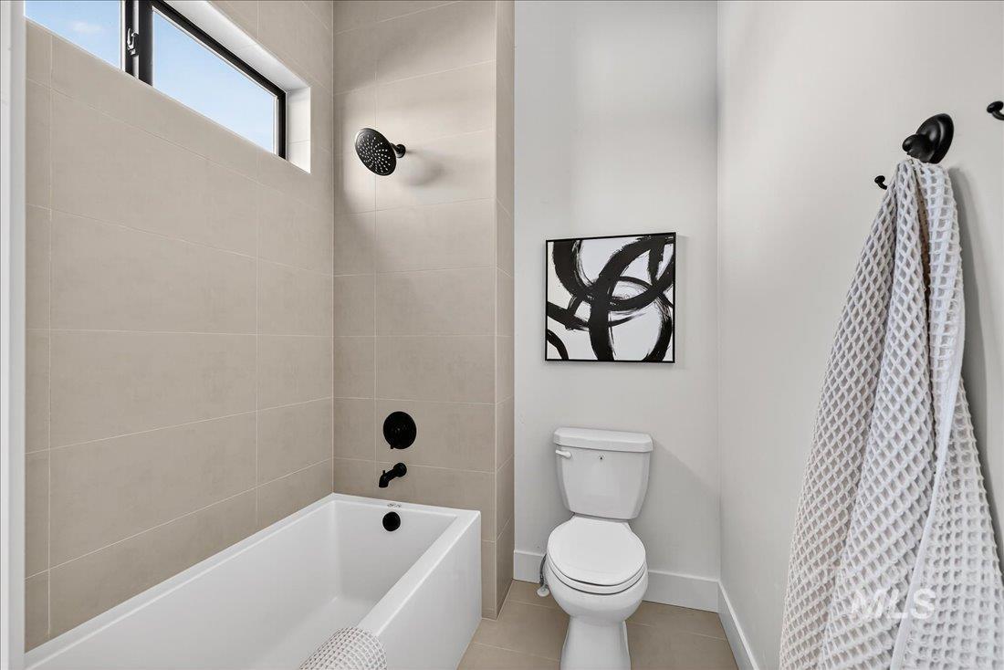 Full bath with shower / tub combination and tile patterned floors