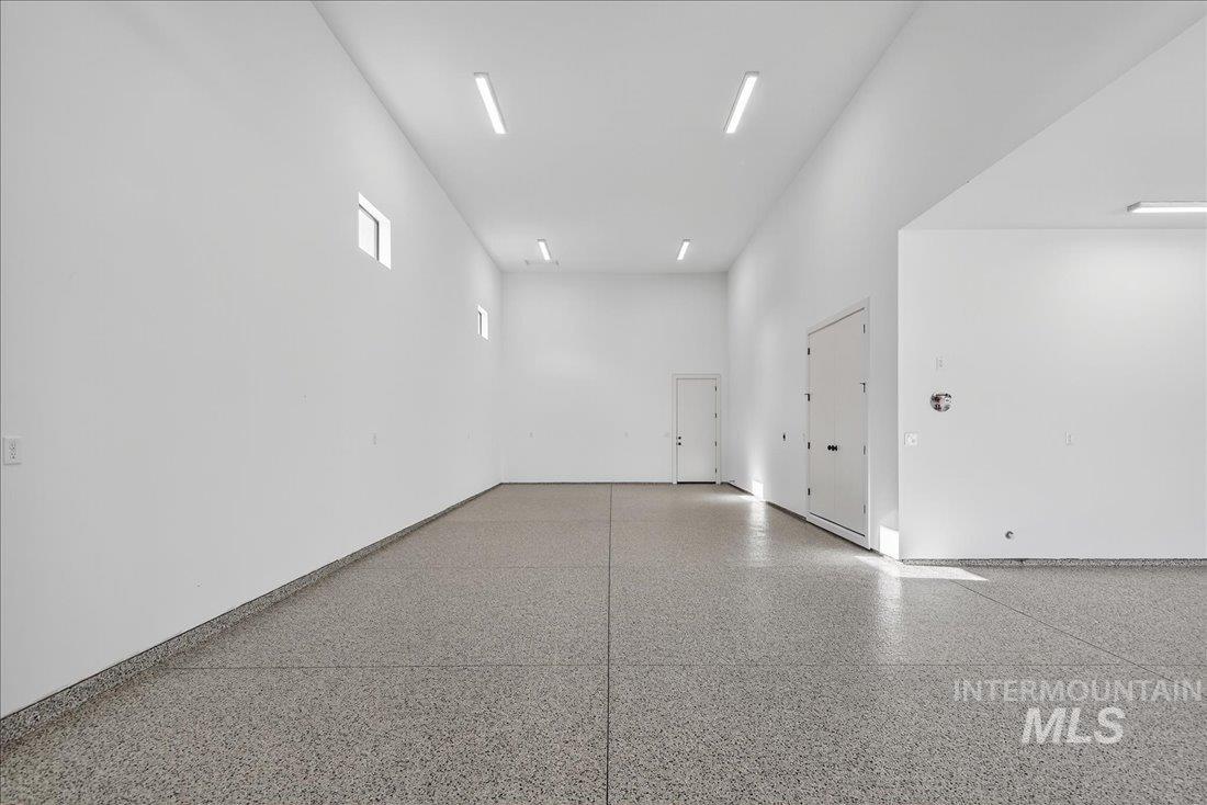 Unfurnished room with a high ceiling and speckled floor