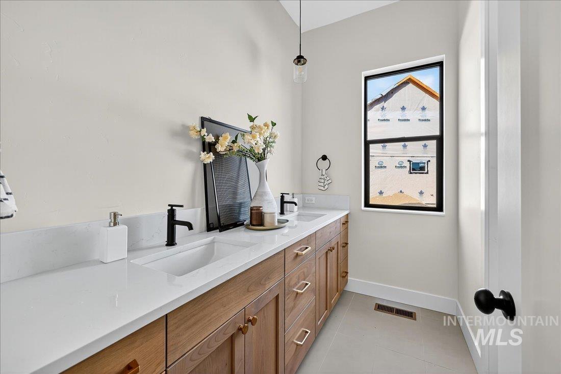 Full bathroom with double vanity and light tile patterned flooring