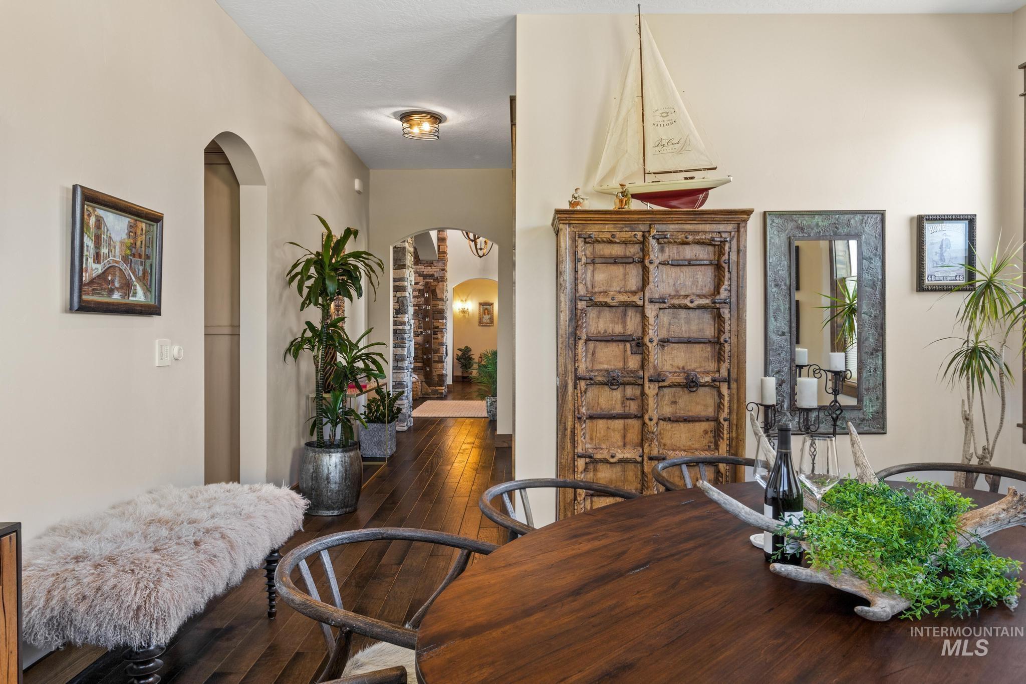 Dining area featuring arched walkways and hardwood / wood-style flooring