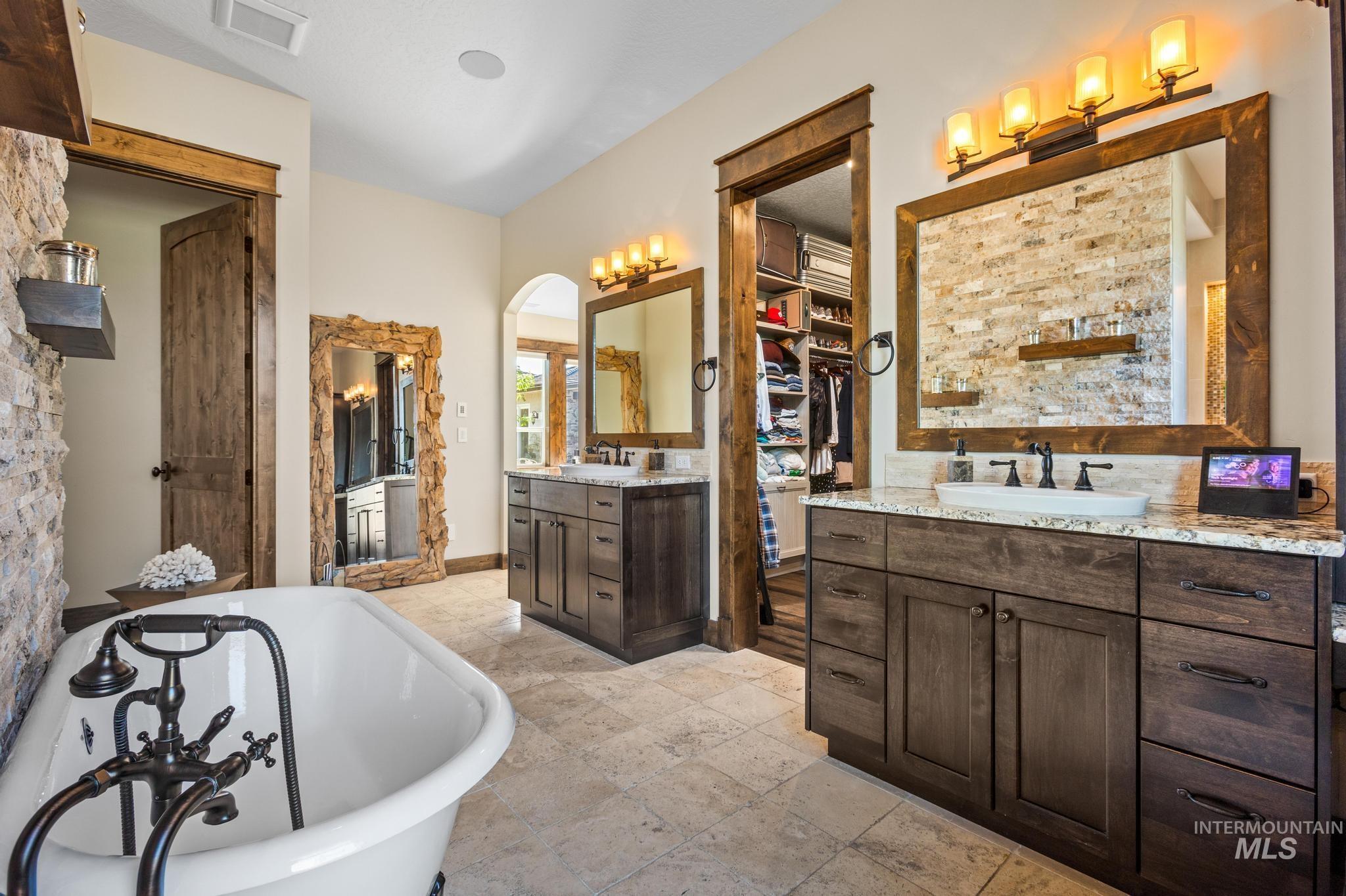 Full bathroom featuring two vanities and a freestanding tub
