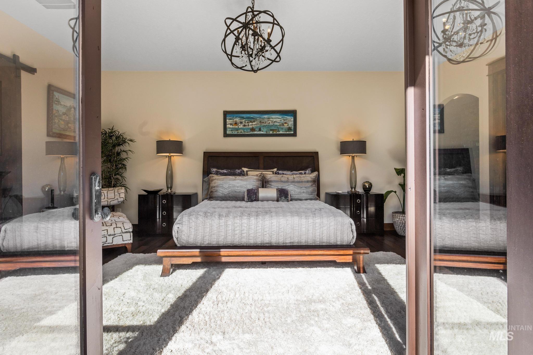 Bedroom with a chandelier and wood finished floors