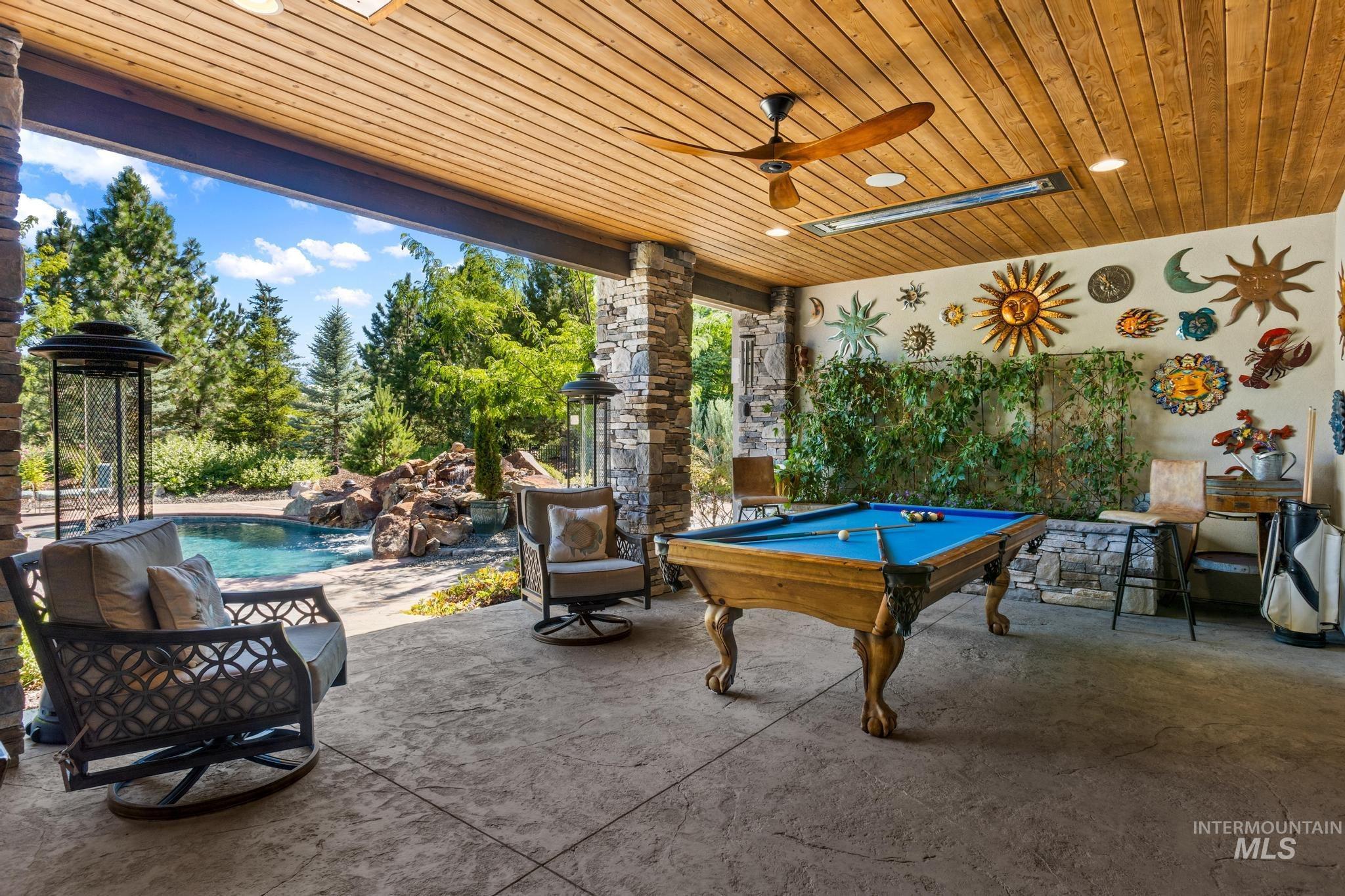 View of patio with a ceiling fan and an outdoor pool