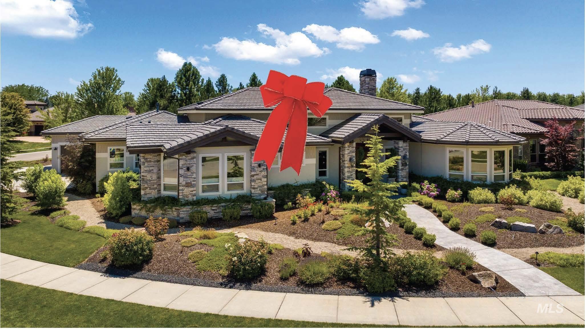 Prairie-style home featuring stone siding, stucco siding, a chimney, and a front lawn