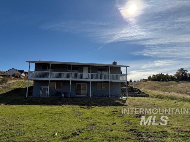 Back of house with a yard and a chimney