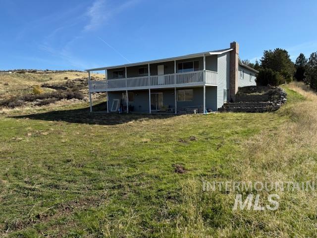 Back of house featuring a yard and a chimney
