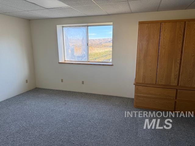 Unfurnished bedroom with carpet and a drop ceiling