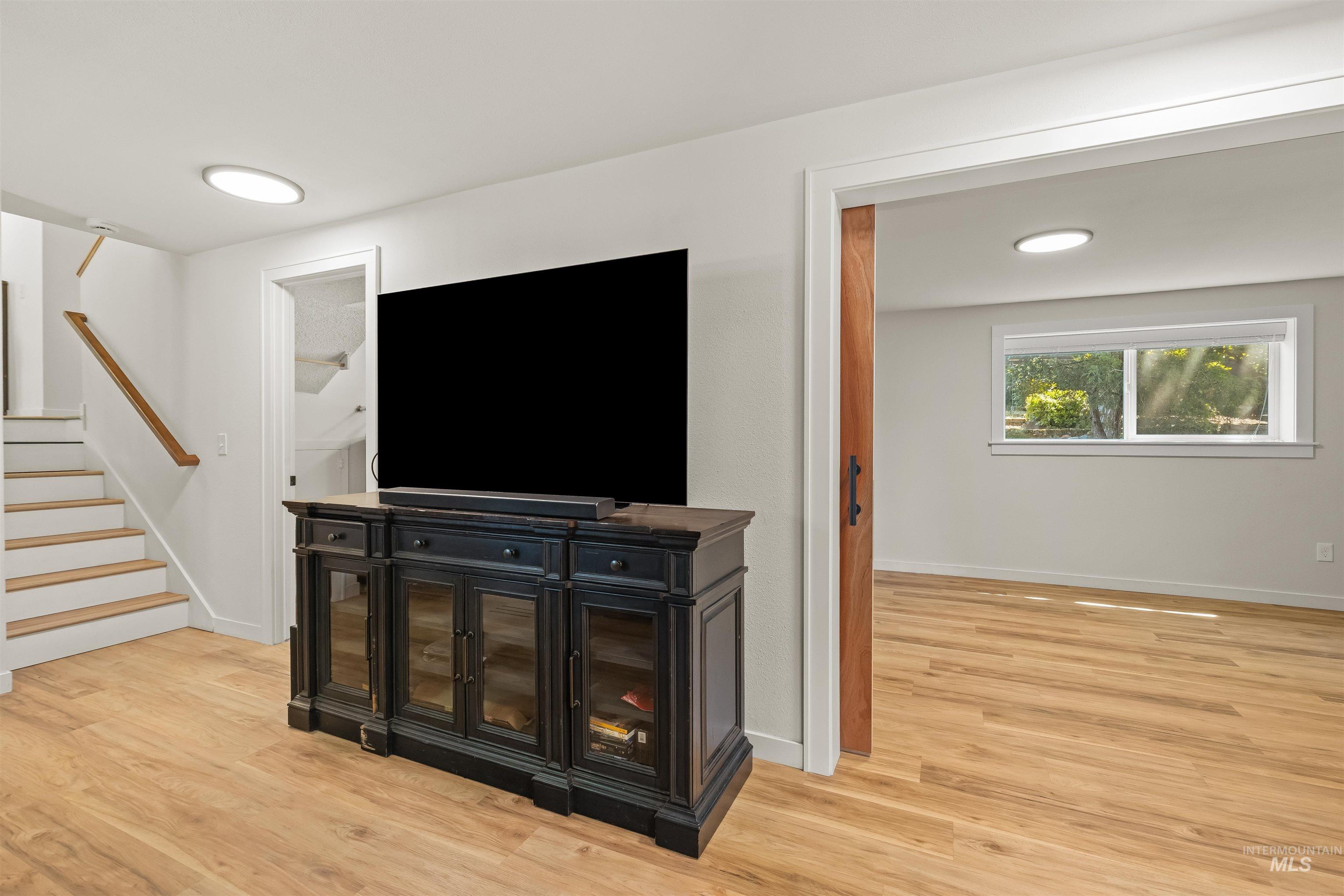 Open concept space featuring light wood-finish flooring, white walls, and recessed lighting