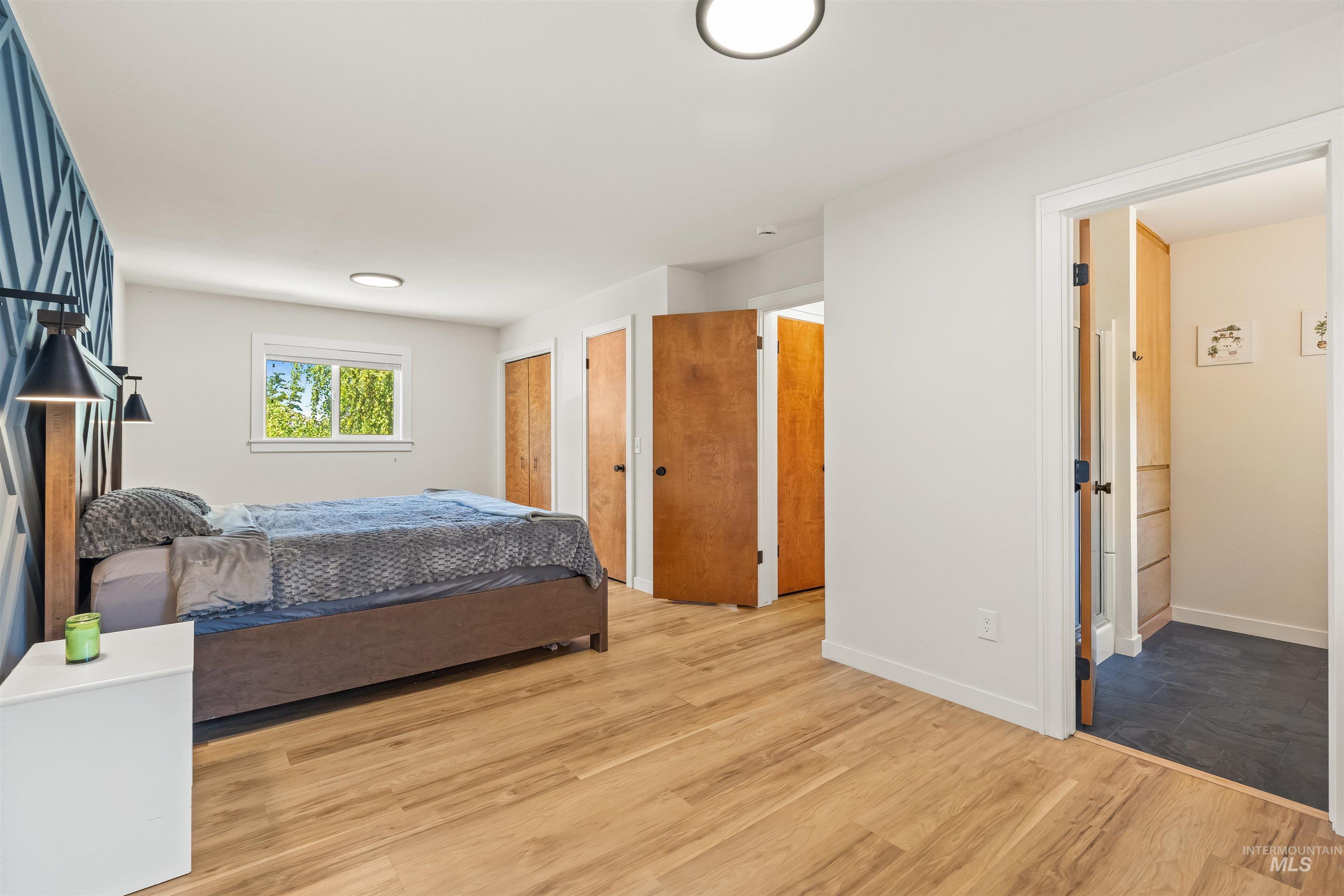 Spacious room featuring wood-finish flooring, a decorative accent wall, and recessed lighting