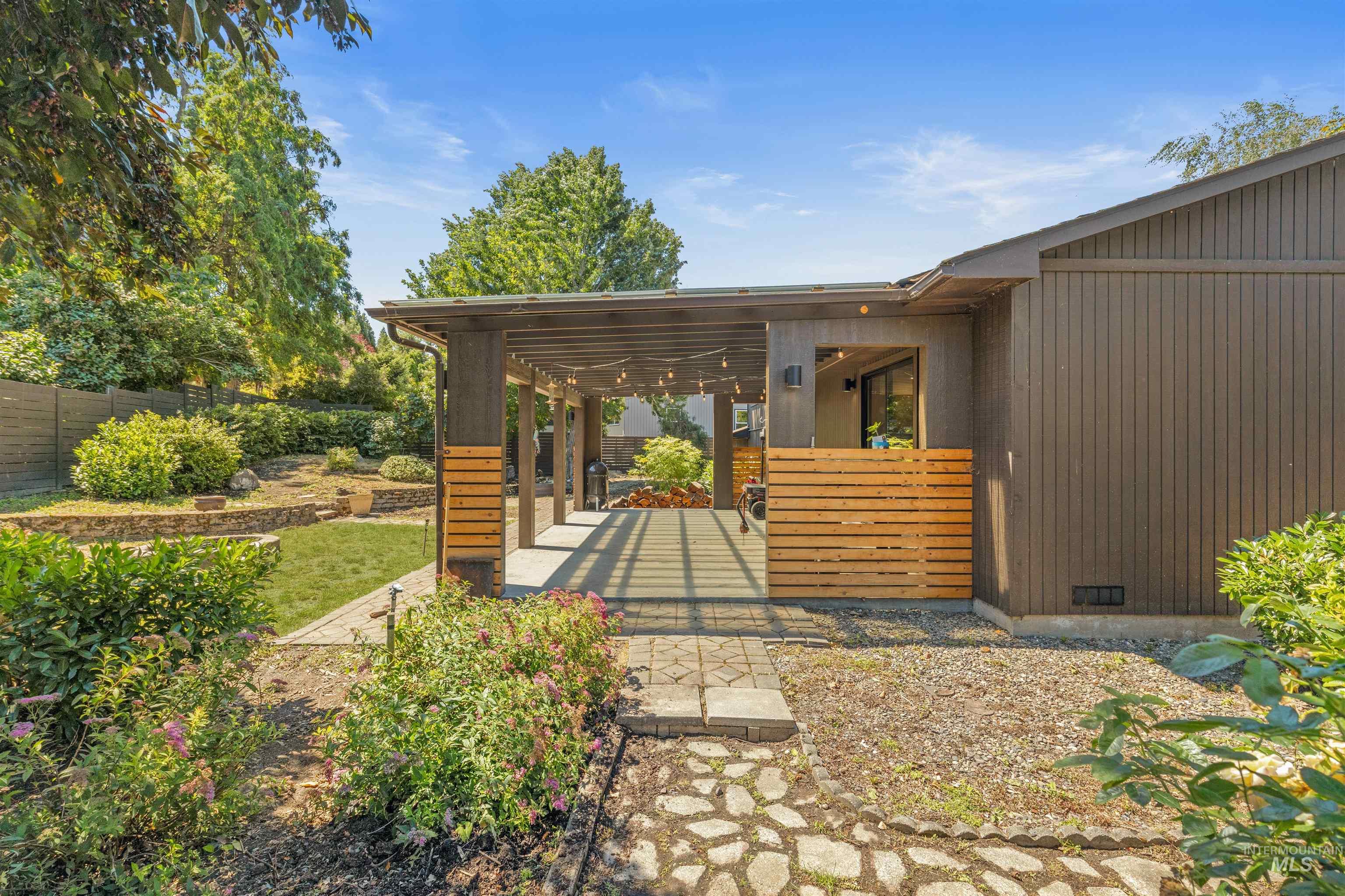 Covered patio featuring string lights, wood slat accents, and a concrete surface