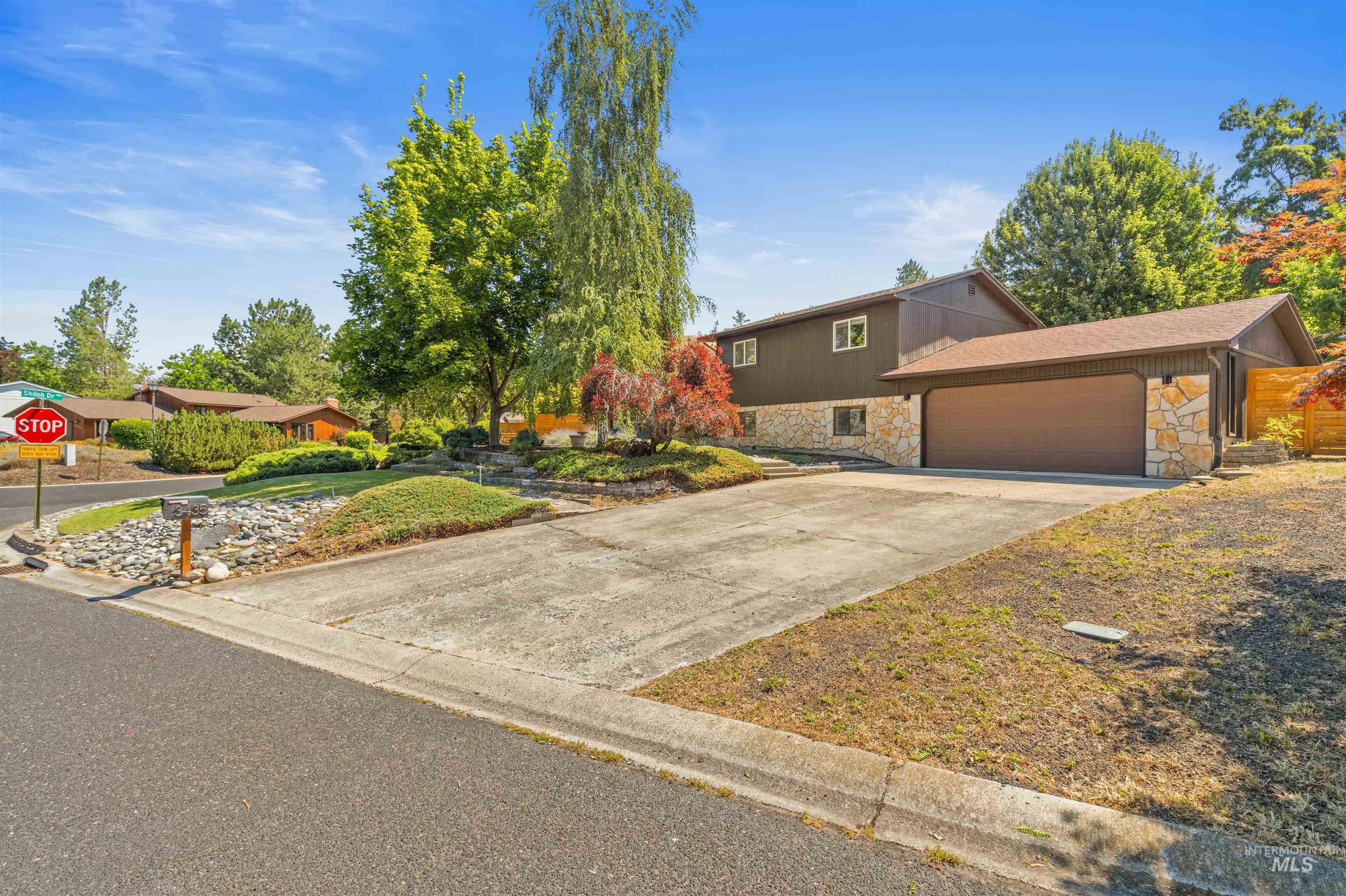 Split-level home featuring a stone veneer foundation and a two-car garage