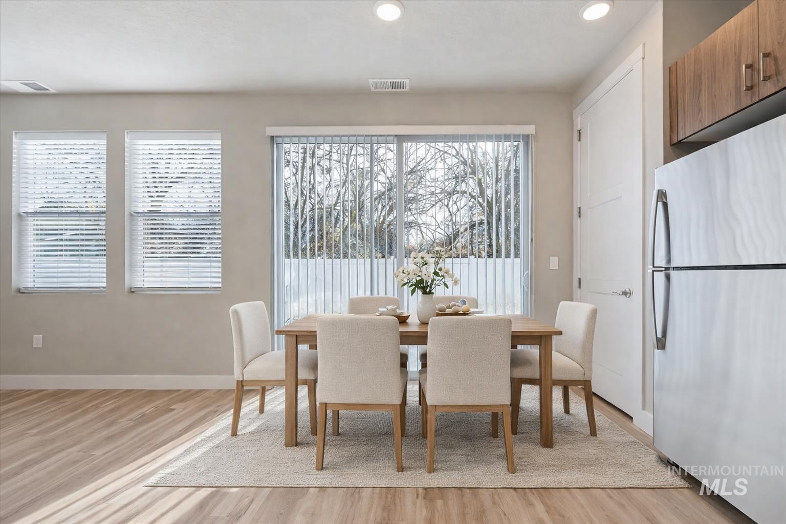 Dining area featuring light wood-style flooring, healthy amount of natural light, and recessed lighting