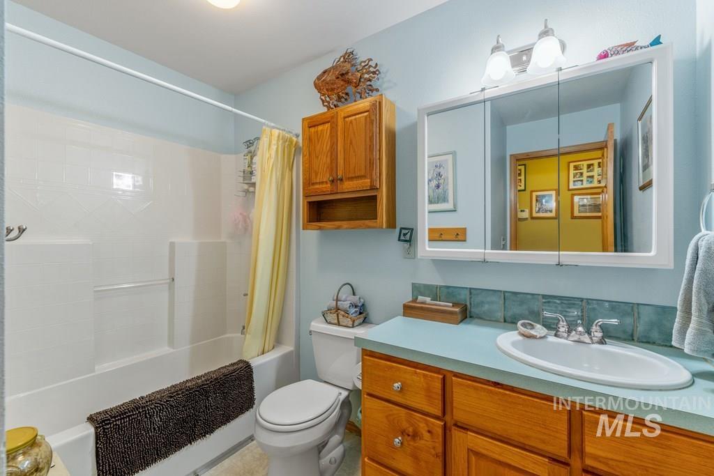 Full bathroom featuring shower / bath combination with curtain and vanity