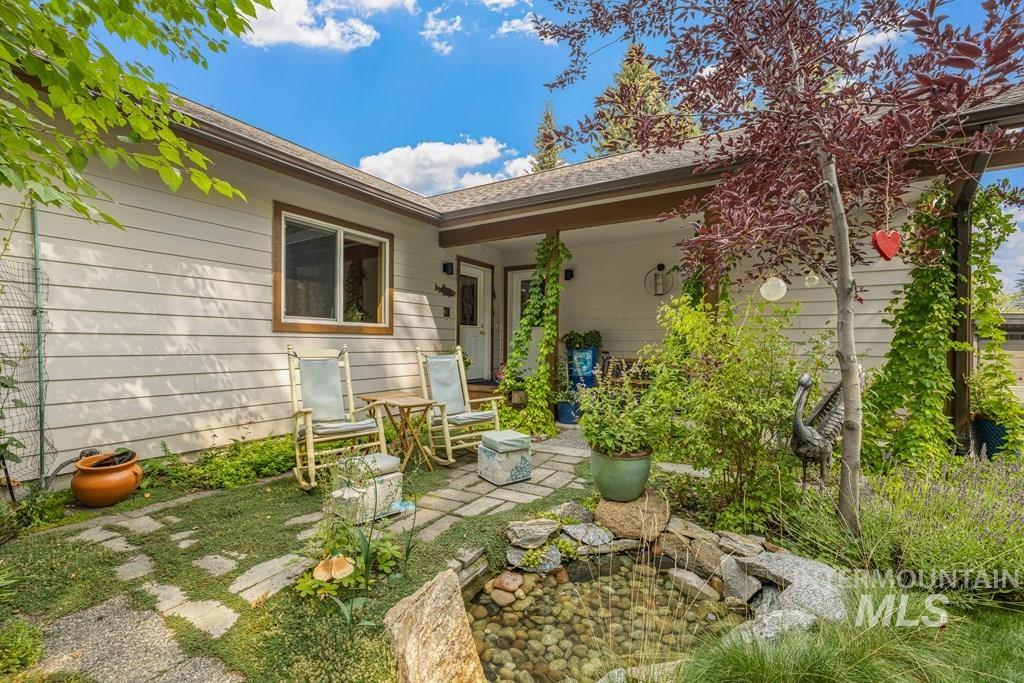 An outdoor nook with a water feature and surrounded by perennials.