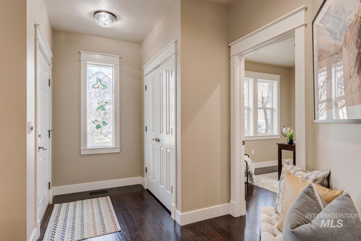 Foyer entrance featuring plenty of natural light and dark wood-style floors