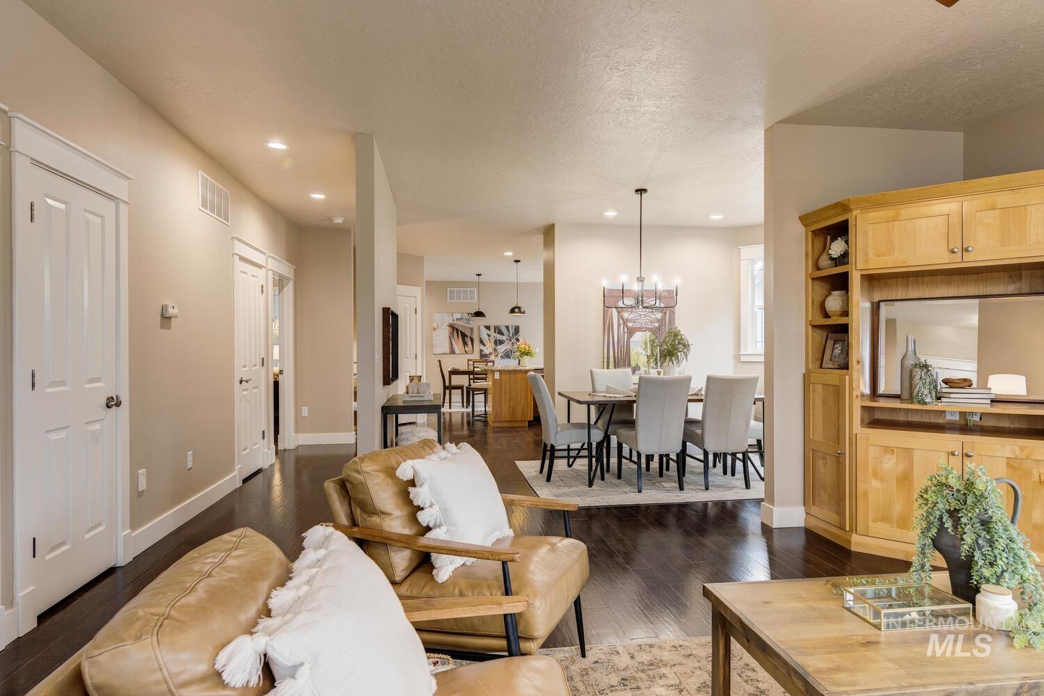 Living area with dark wood-style flooring, recessed lighting, a textured ceiling, and a chandelier