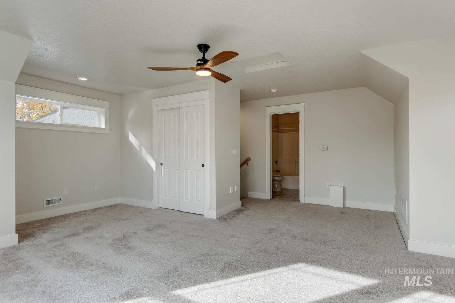 Bonus room featuring light carpet and ceiling fan