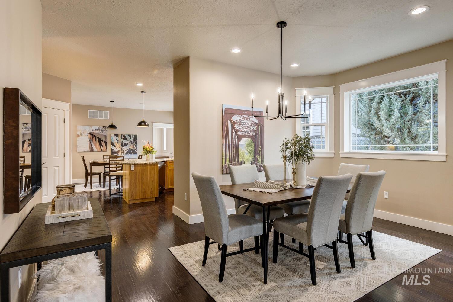 Dining space featuring dark wood finished floors, recessed lighting, and a chandelier