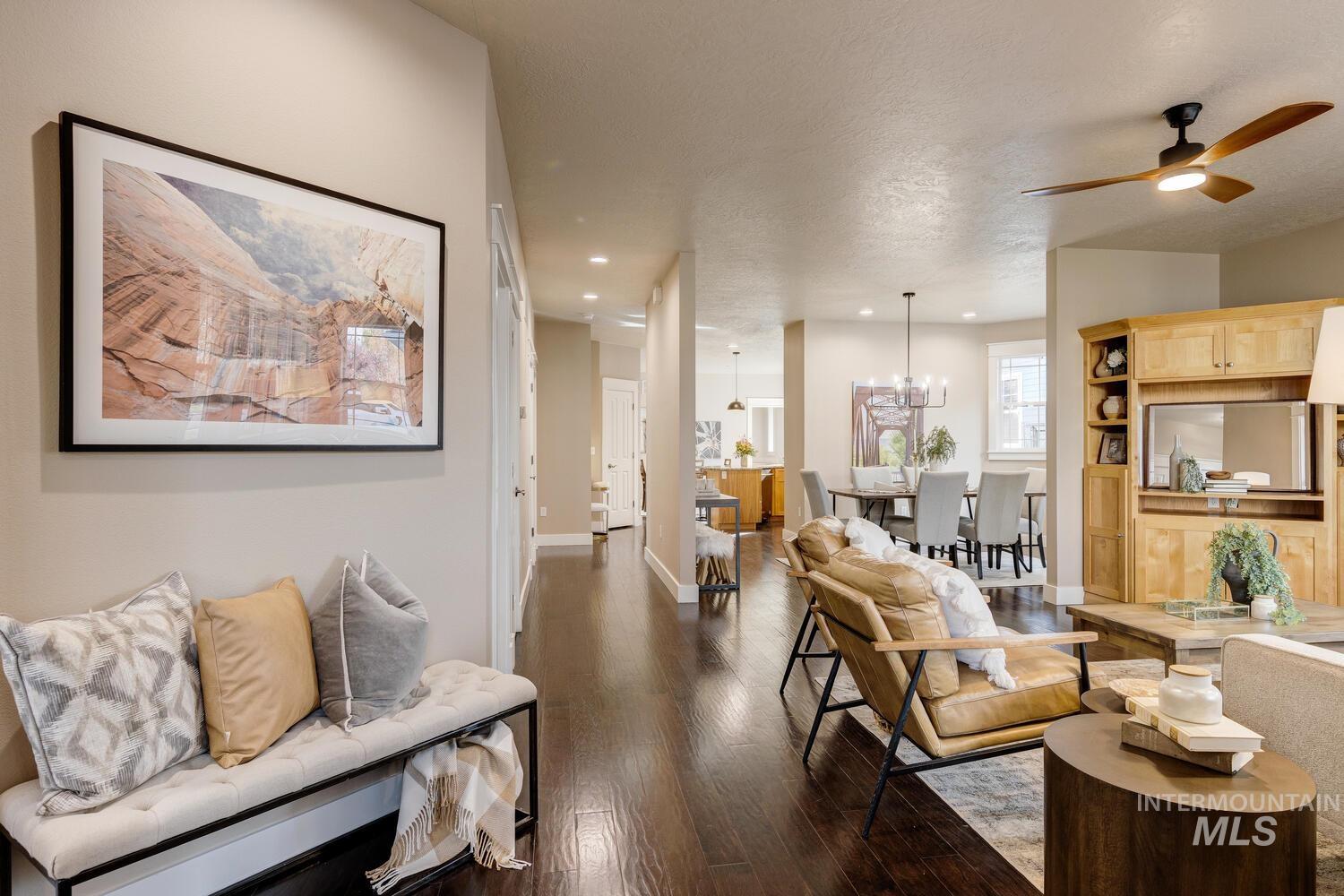 Living area with dark wood finished floors, ceiling fan, a textured ceiling, recessed lighting, and a chandelier