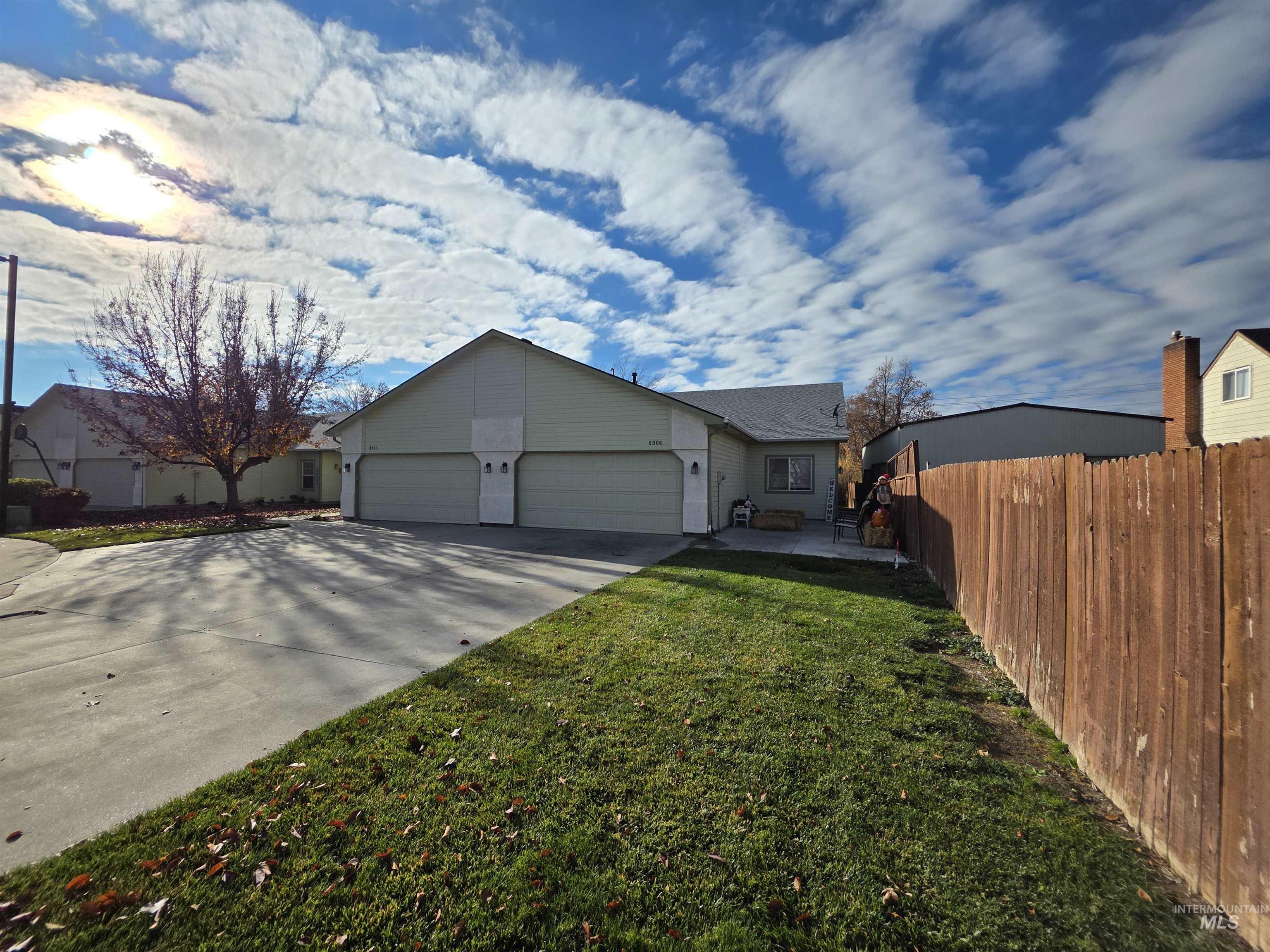 Ranch-style home featuring driveway, an attached garage, and a patio area
