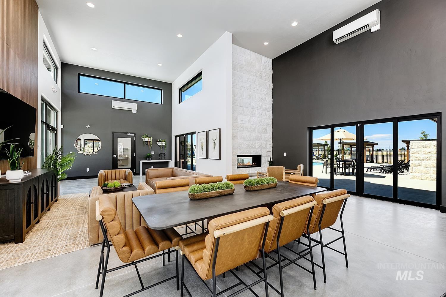 Dining area with a high ceiling, finished concrete floors, a wall mounted AC, a fireplace, and recessed lighting