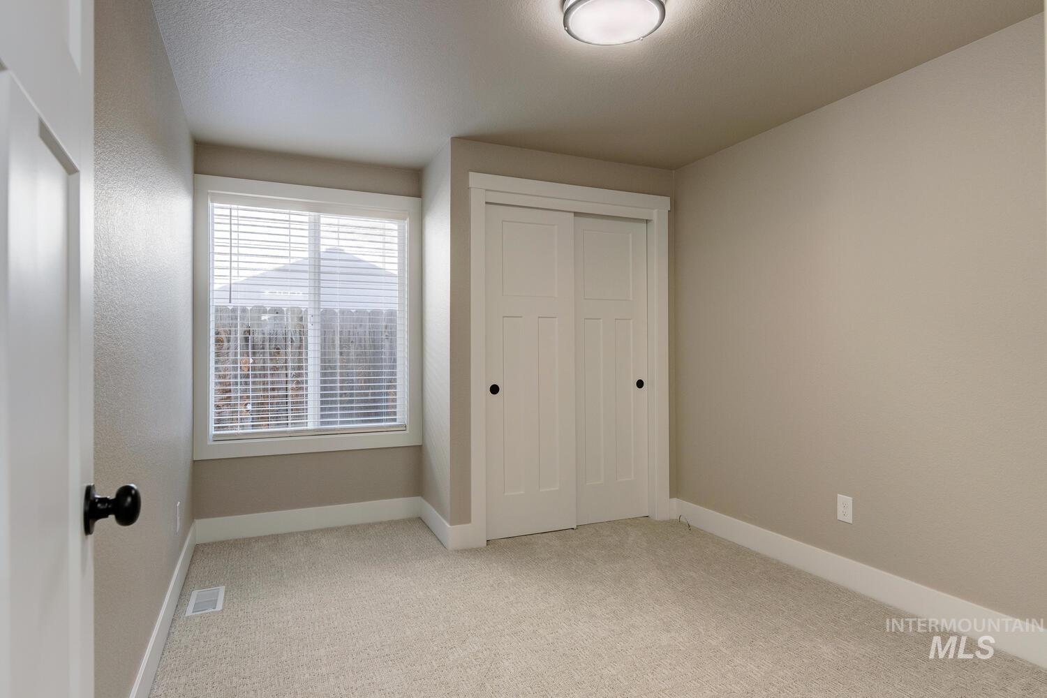 Unfurnished bedroom with light colored carpet and a closet
