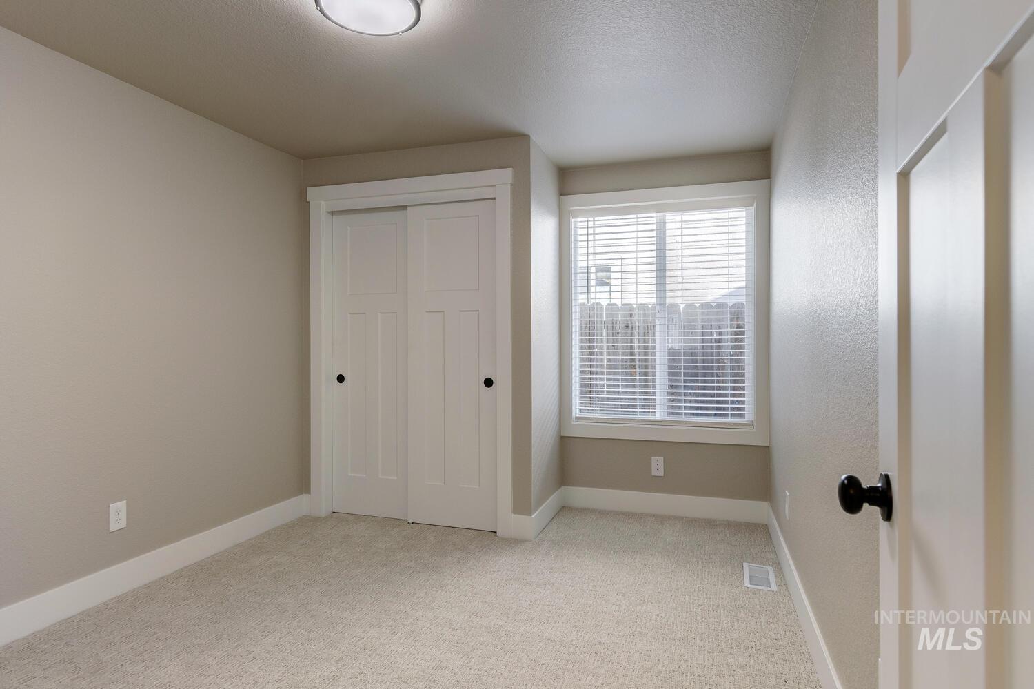 Unfurnished bedroom featuring light colored carpet and a closet