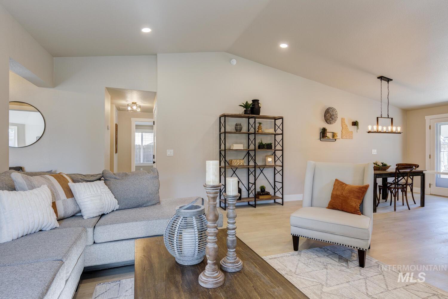 Living room with light wood-style floors, vaulted ceiling, plenty of natural light, and recessed lighting