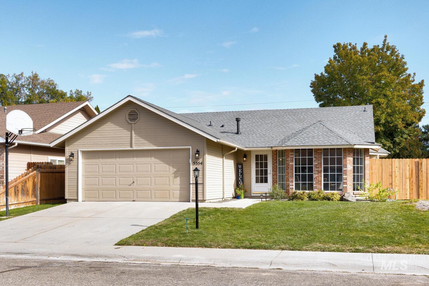 Ranch-style house with a shingled roof, concrete driveway, and an attached garage