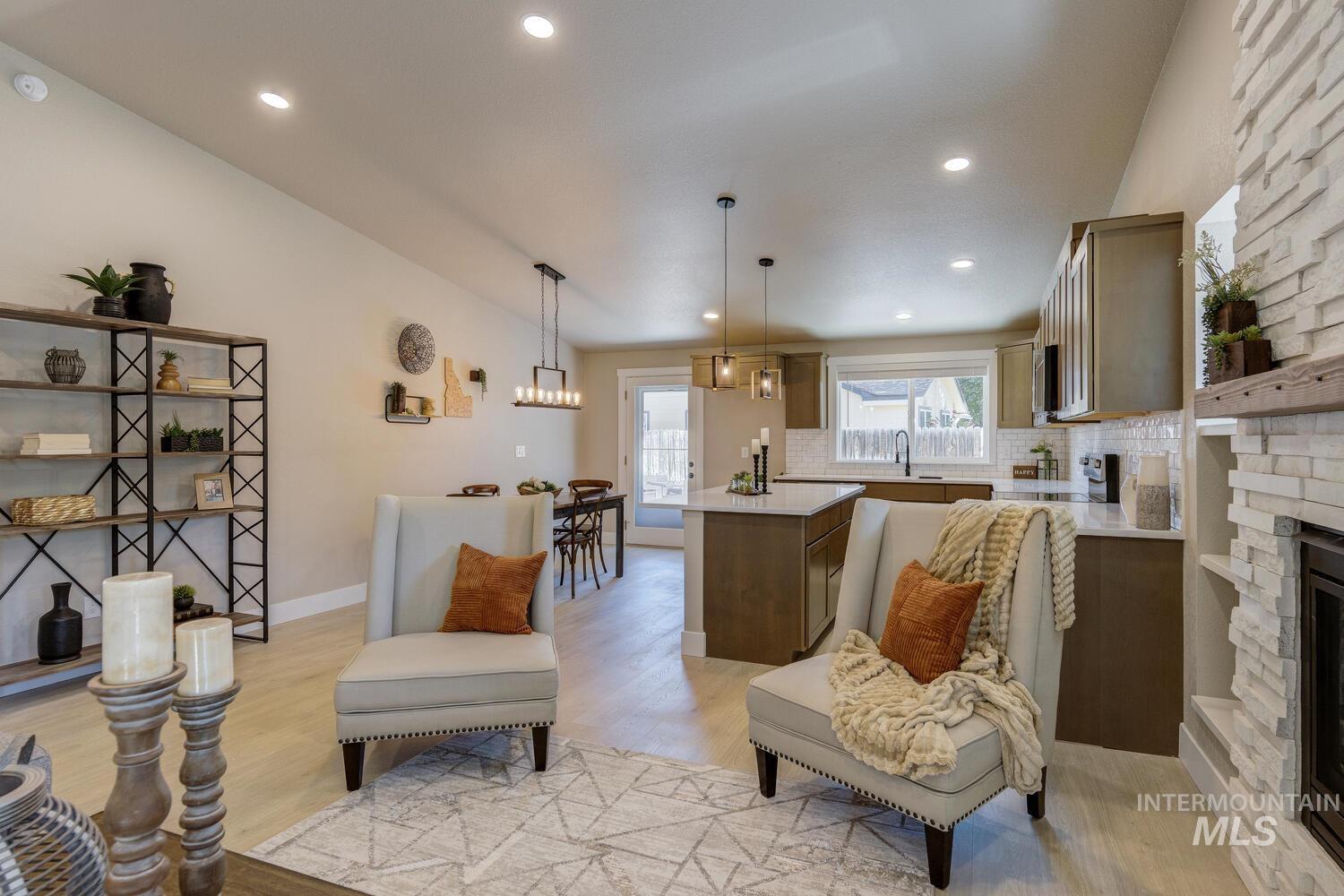 Living room with light wood-type flooring, recessed lighting, a fireplace, and lofted ceiling