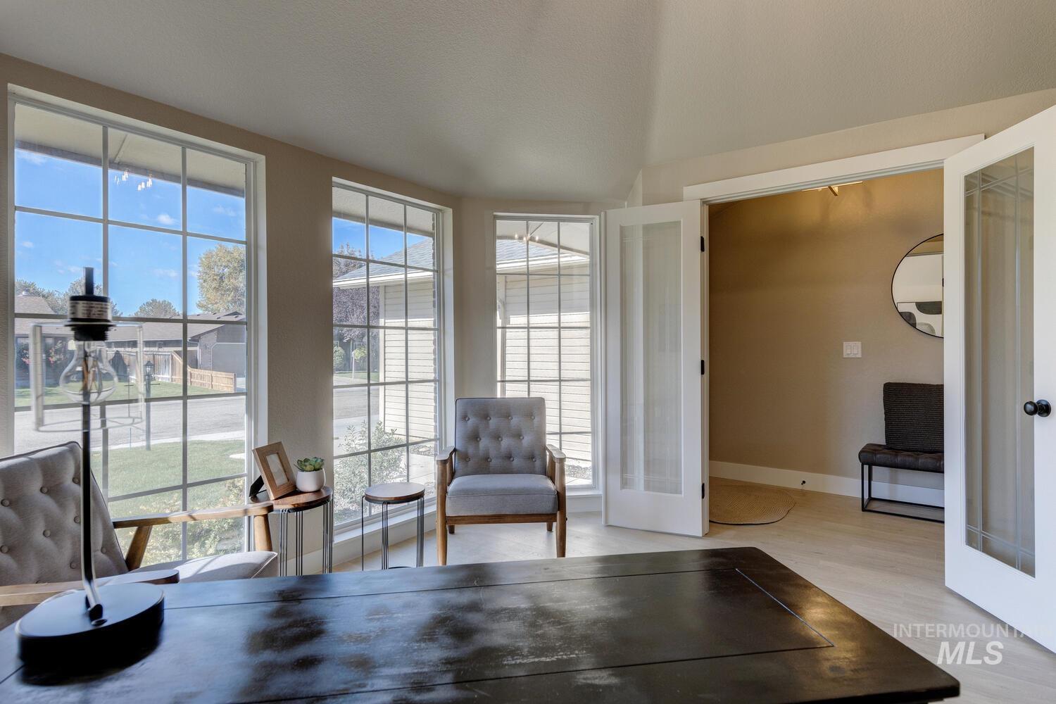Living area featuring light wood finished floors, healthy amount of natural light, and french doors