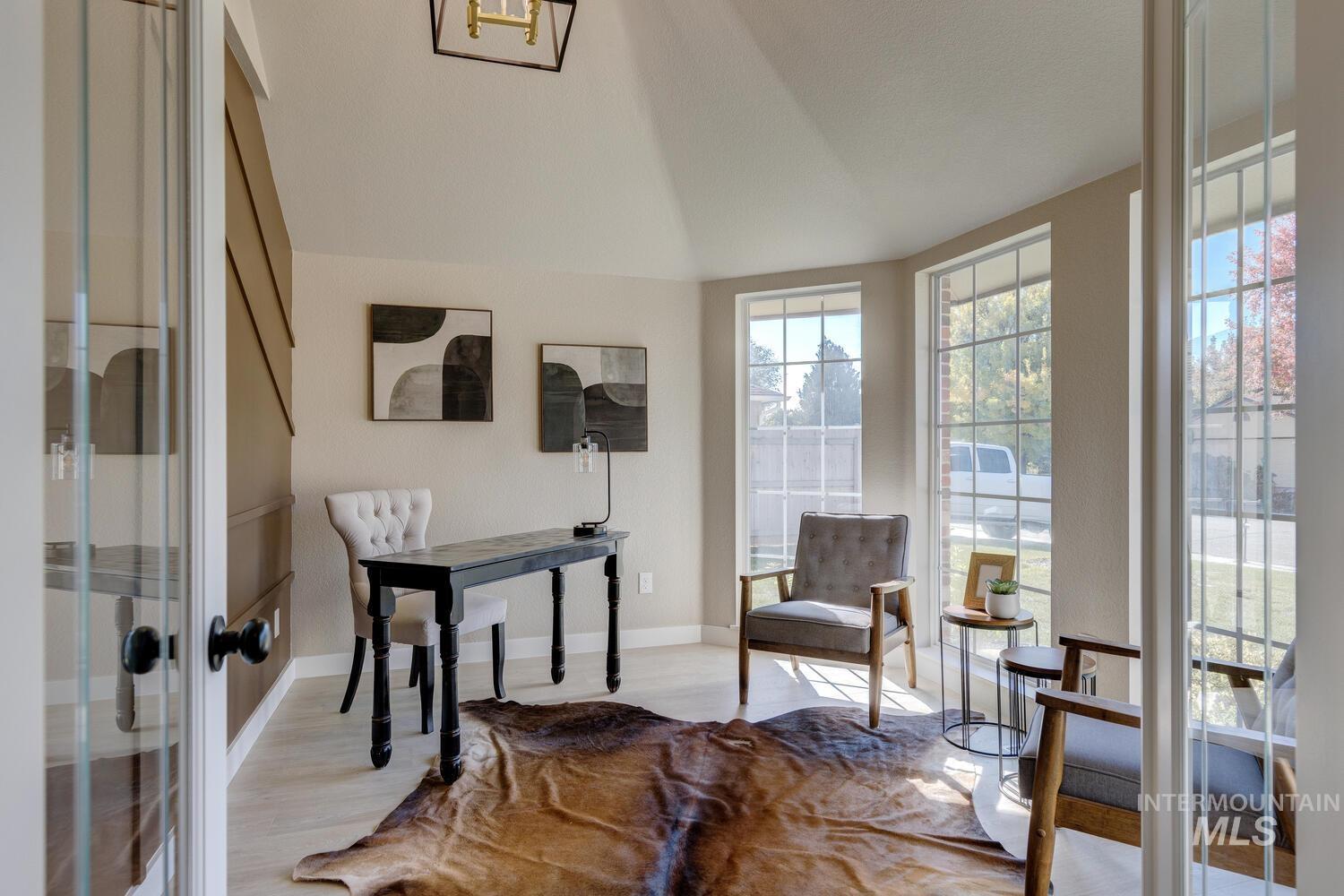 Sitting room featuring light wood-style flooring, vaulted ceiling, and french doors