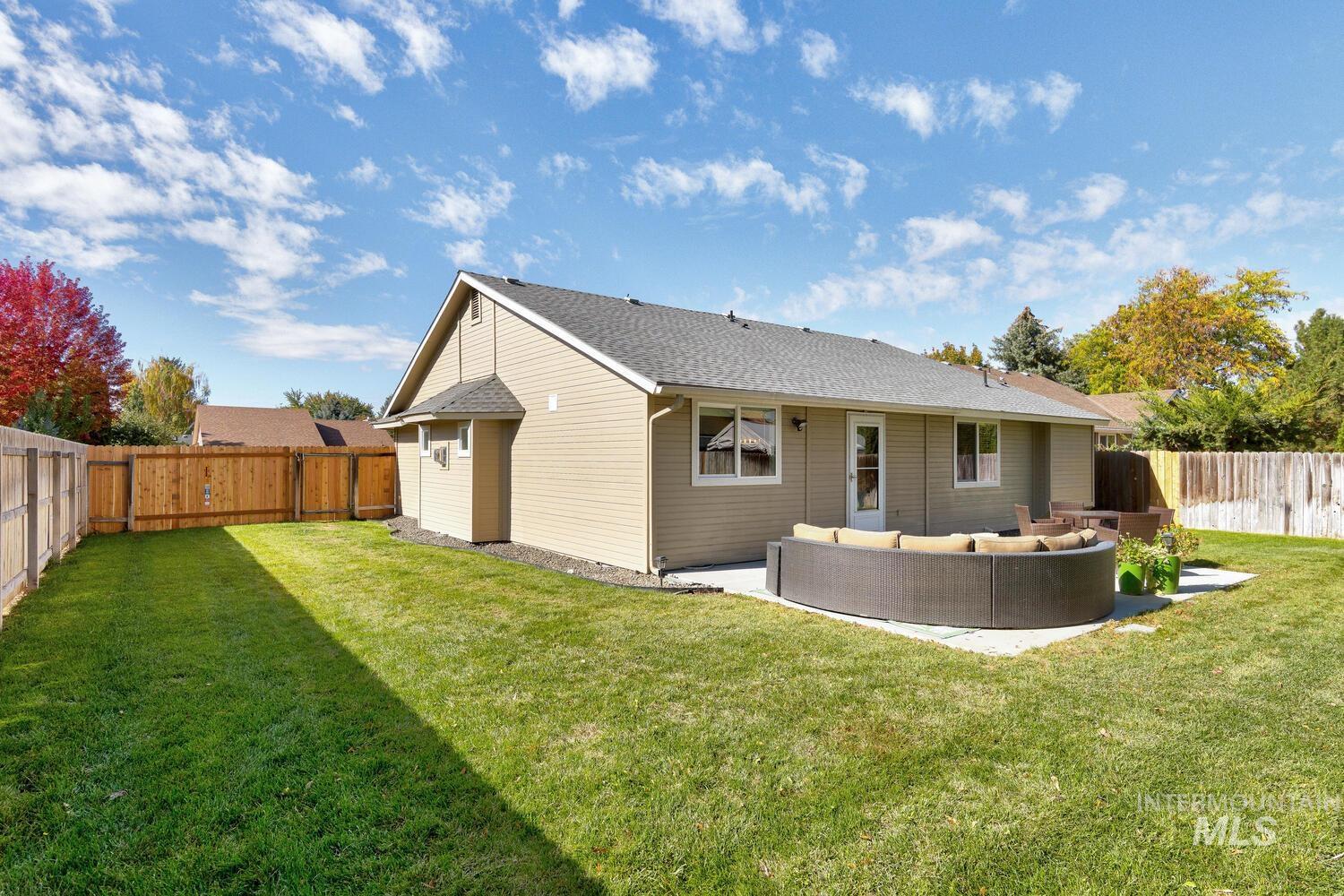 Back of property featuring an outdoor living space, a fenced backyard, a patio area, and a shingled roof