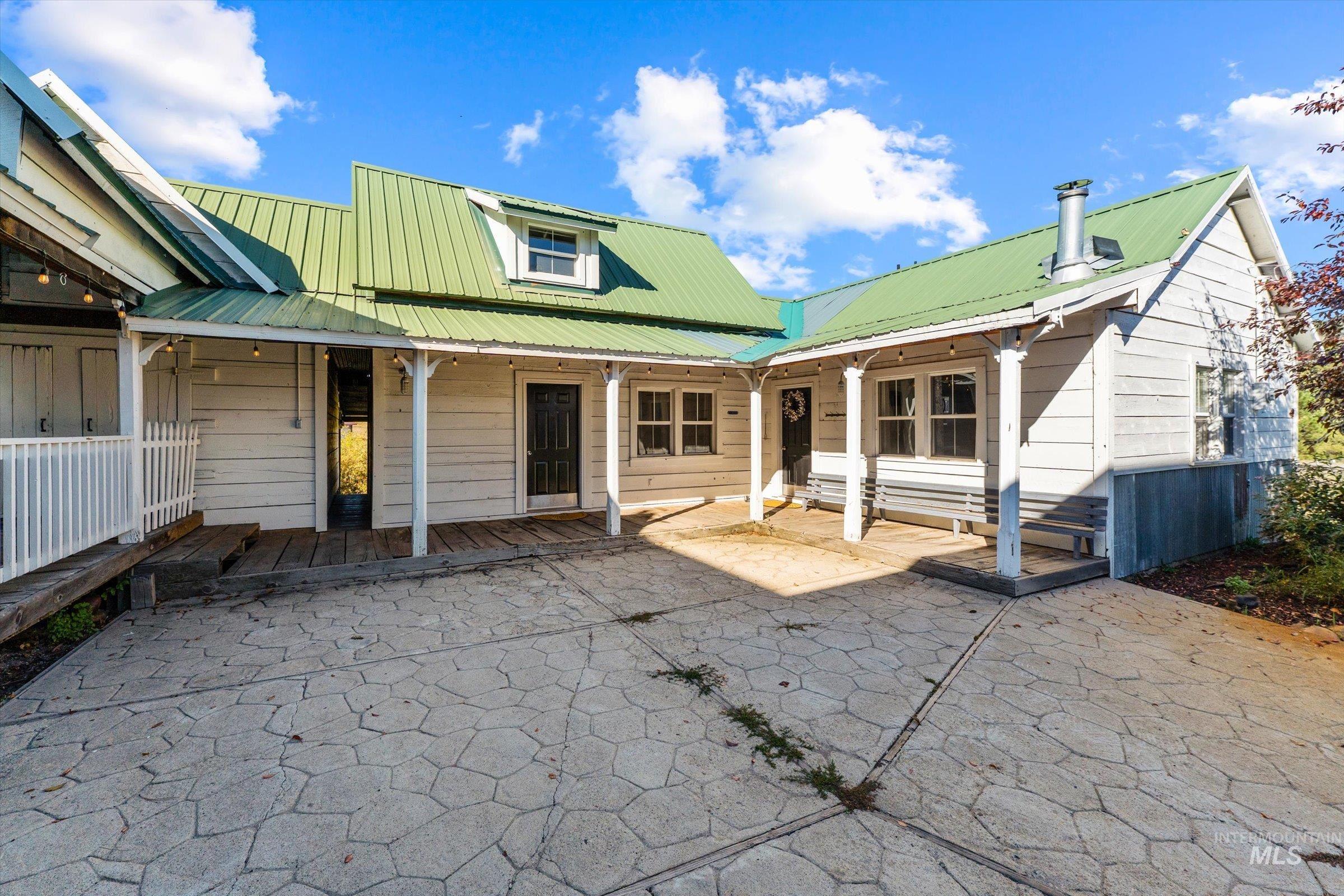 Back of house with a metal roof and a patio