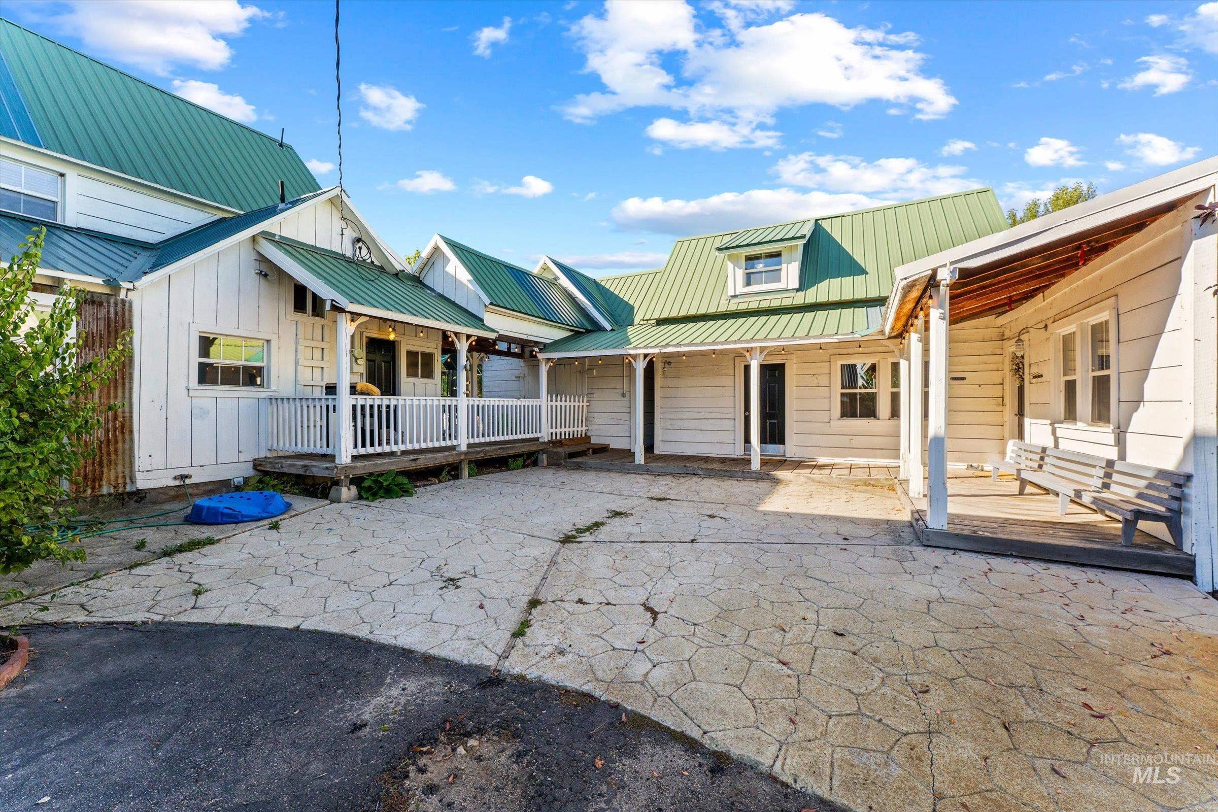 Back of property with a patio, a metal roof, and board and batten siding