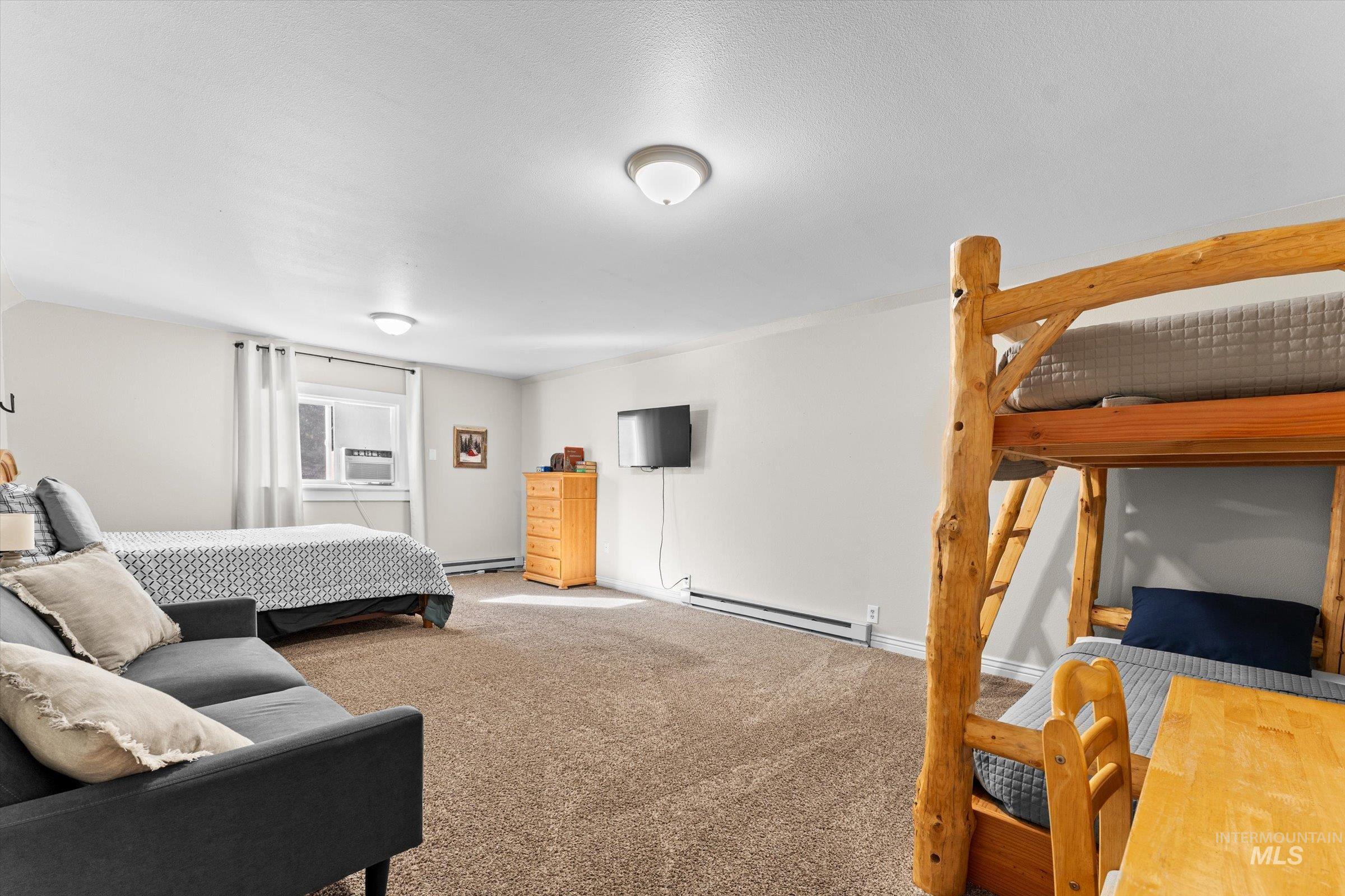 Bedroom featuring carpet and baseboard heating