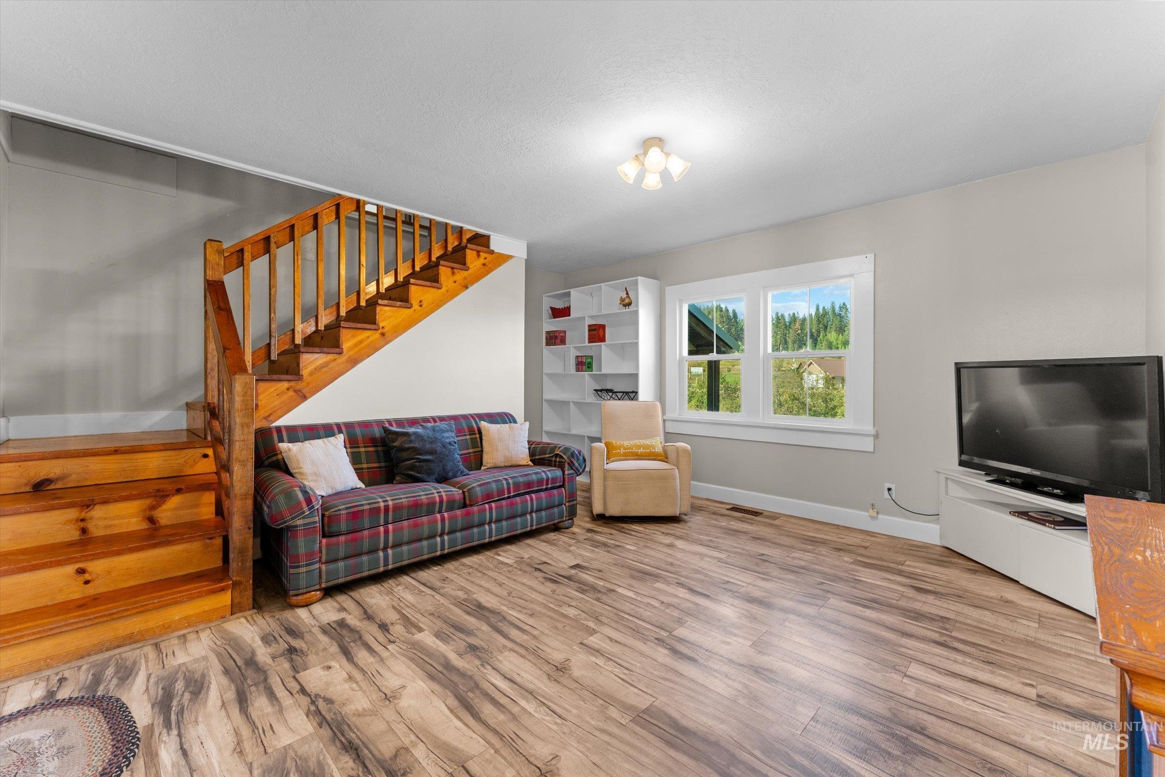 Living room featuring stairs and wood finished floors
